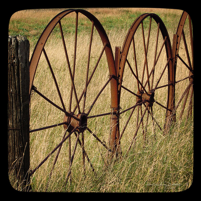 Close up view of part of a metal wagon wheel fence/
